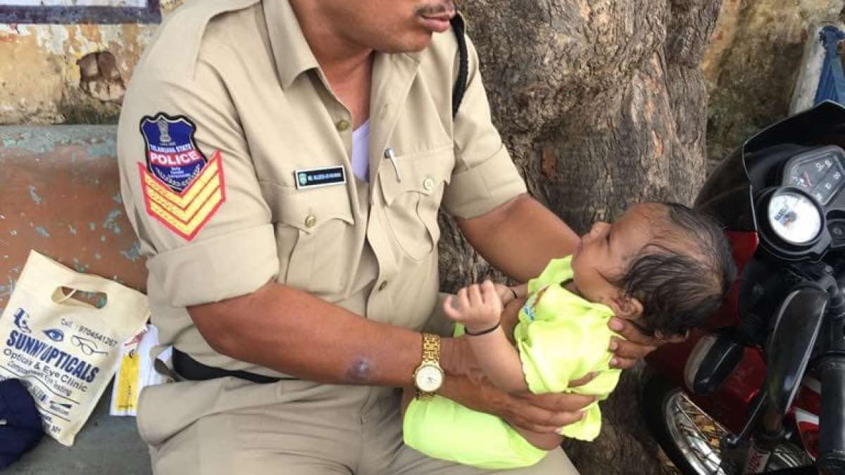 Viral photo of Policeman caring baby (Representational Image) Viral photo of Policeman caring baby (Representational Image)